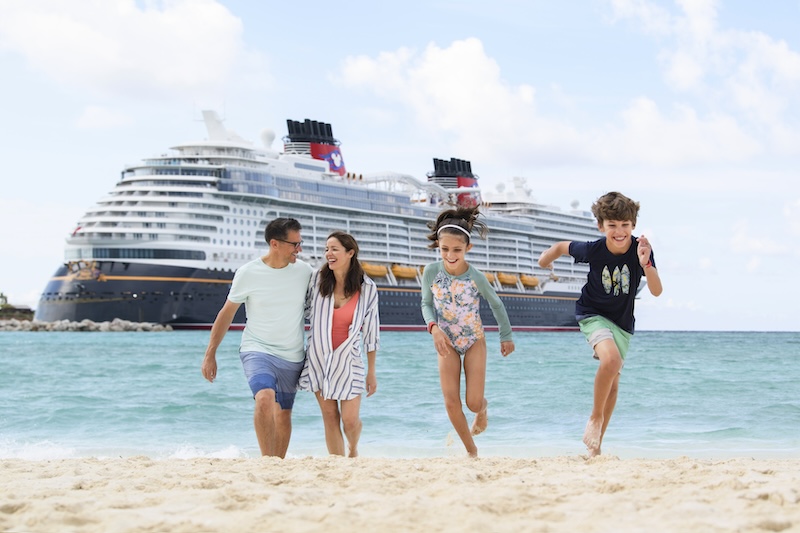 Family on beach with Disney cruise ship